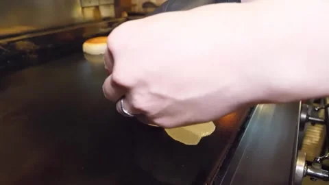 Chef Cracking Fresh Egg on Commercial Griddle Next to Toasted Buns Stock-Footage 347689545