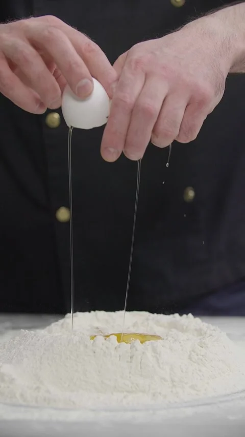 Chef Cracking Fresh Egg Into Flour for Homemade Dough Vídeo Stock 341417505