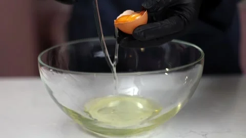The chef cracks the egg to separate the yolk Stock Footage 275146099