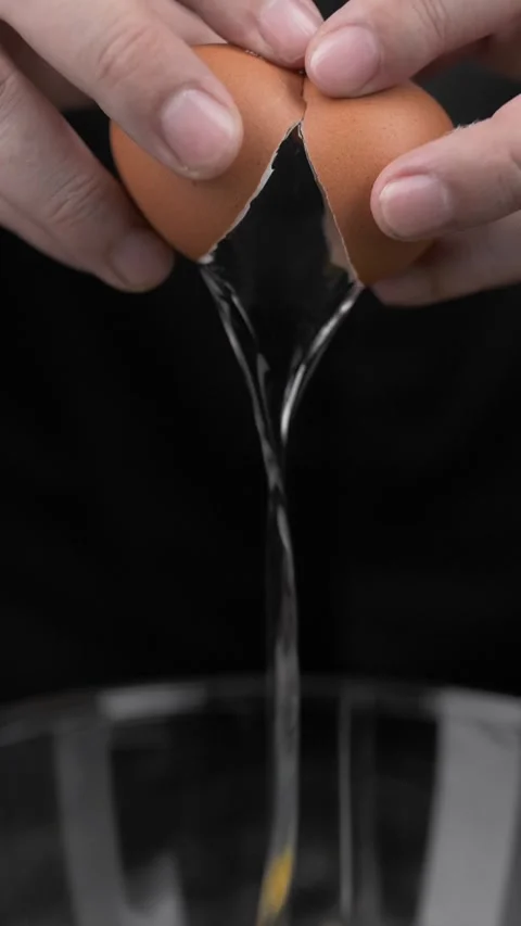 Chef cracks raw chicken egg into cooking bowl. Stock Footage 281660451