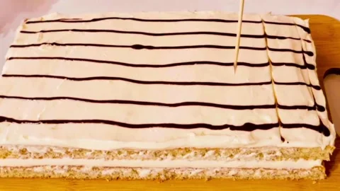 Chef creating a marble pattern on cake icing with a toothpick for dessert design Stock Footage 327258942