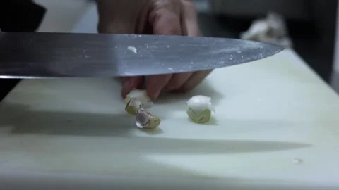 Chef crushing and peeling garlic cloves with a knife Stock Footage 335834957