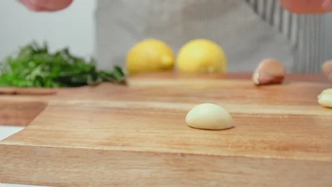 Chef crushing garlic close-up and squeeze with a side knife in 4K. Stock Footage 145998026