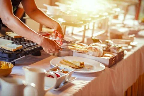 Chef cut bread by scissors and bread on grilling. Stock Photos