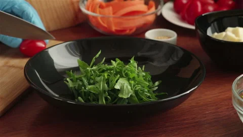 Chef cut cherry tomatoes and put on fresh arugula leaves salad Stock Footage 120058239