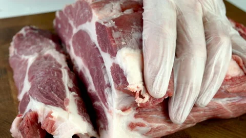 Chef cut quality raw meat with sharp knife into steak before cooking. Stock Footage 234065529