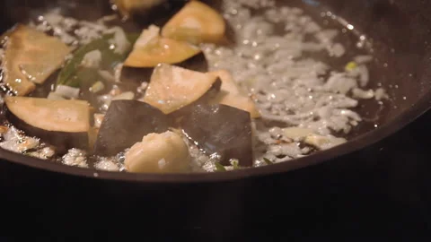 The chef cuts and roasts vegetables in a frying pan Stock Footage 158020537