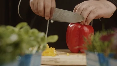 Chef cuts arge red pepper in the kitchen with sharp knife. Slicing sweet pepper Stock Footage 113513323
