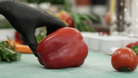 Chef cuts arge red pepper in the kitchen with sharp knife. Slicing sweet pepper. Stock Footage 124322443
