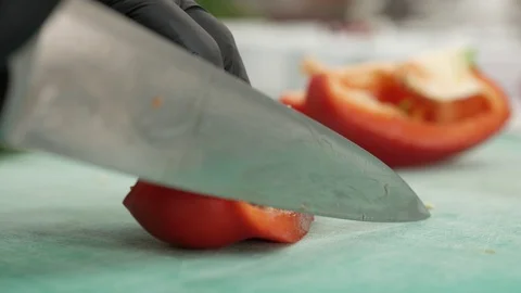 Chef cuts arge red pepper in the kitchen with sharp knife. Slicing sweet pepper. Stock-Footage 124322936
