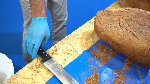 Chef cuts bread at the market place. Vidéo 121878446
