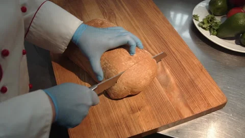 The chef cuts bread for a sandwich Stock Footage 158021765