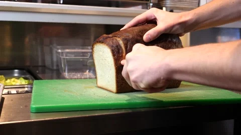 Chef cuts bread for a sandwich 库存影片 201894399
