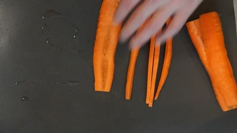 Chef cuts carrot. Cooking process. Hands cutting carrot. Chef slices the carrot Stock Footage 100106076