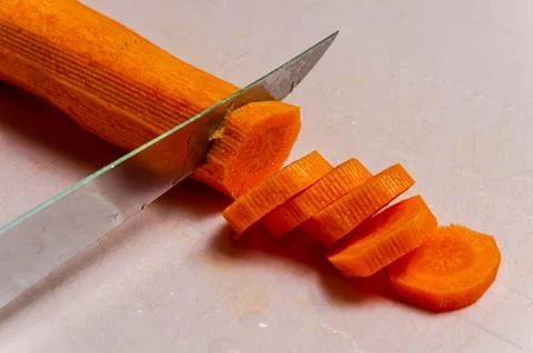 The chef cuts a carrot with a knife Stock Photos