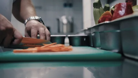 Chef cuts carrot with a sharp knife Stock Footage 112589015