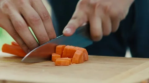 Chef cuts carrots with a knife hands close up Stock Footage 130894597