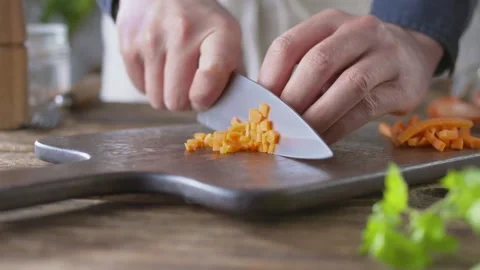 Chef cuts carrots for salad with a sharp knife. male chef prepares salad in the Video stock 144677379