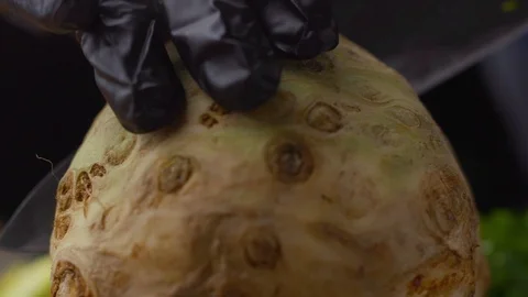 Chef cuts celery root into two parts Stock Footage 121701854