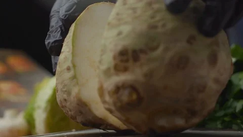 Chef cuts celery root into two parts Stock Footage 121701857