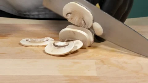 The chef cuts champignons for a dish Stock Footage 306803481