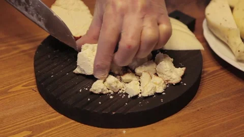 A chef cuts cheese on a cutting board. Close up Video stock 130655979