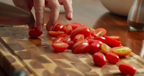 A chef cuts cherry tomatoes. Cook cutting cherry tomatoes for spaghetti with Stock Footage 319297122