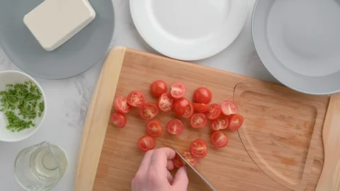 Chef cuts cherry tomatoes. Vegan food. Summer refreshing salad. Stock Footage 129777359