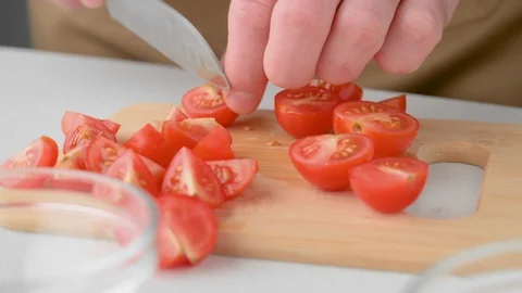 Chef cuts cherry tomatoes. Vegan food. Cooking summer refreshing salad. Stock Footage 129946366