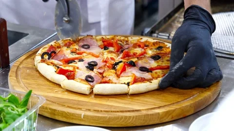 The chef cuts the cooked pizza into pieces Stock Footage 232580949