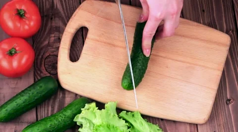 Chef Cuts the Cucumber on the Board. on the Table Lay the Tomatoes and Lettuce. Video stock 61883251