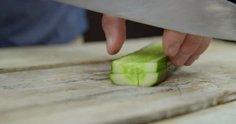 The chef cuts the cucumber into cubes on the Board Stock Footage 113422831