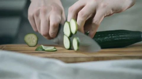Chef cuts the cucumber with a sharp knife in the kitchen on a wooden board Stock Footage 68721966