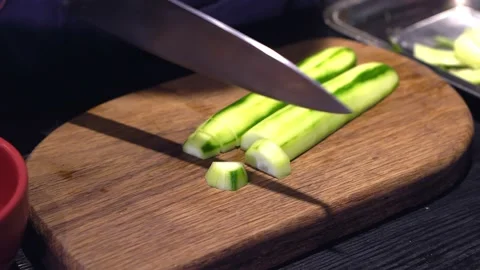 The chef cuts cucumbers for a delicious salad. Close up. Stock Footage 171682116