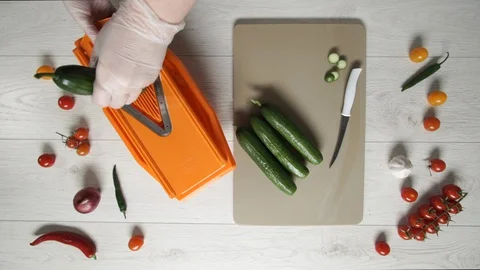 Chef cuts cucumbers on plastic Grater Stock Footage 128324442