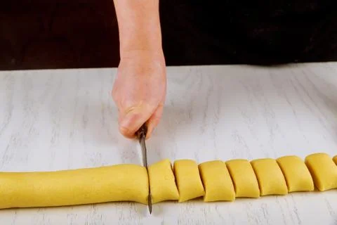 Chef cuts dough with a knife in equal portion for cooking biscuits. Stock Photos