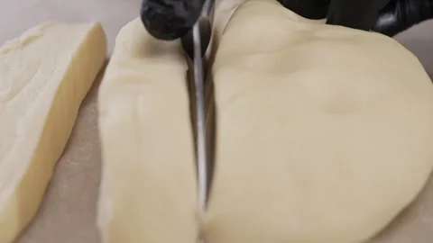 Chef cuts the dough on the table. Stock Footage 310580809