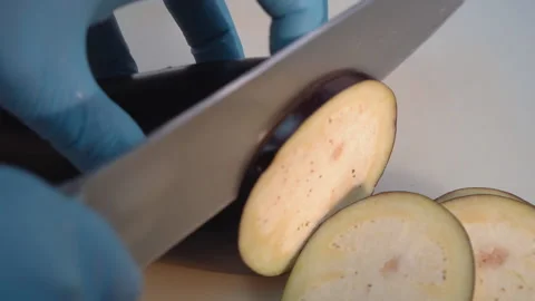 The chef cuts the eggplant into thin slices Stock Footage 158020331
