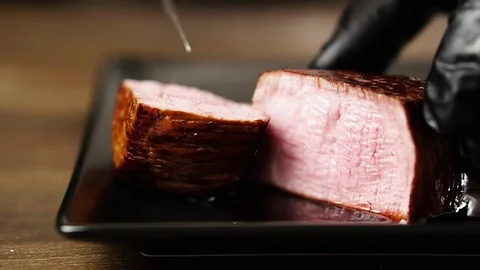 Chef cuts a filet mignon steak and shows it in a cut. Stock Footage 126221010