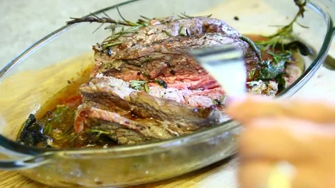 A chef cuts a fillet of cooked meat Stock Footage 77078566