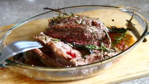 A chef cuts a fillet of cooked meat Stock Footage 77078608