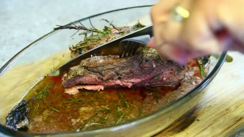 A chef cuts a fillet of cooked meat Stock Footage 77078717