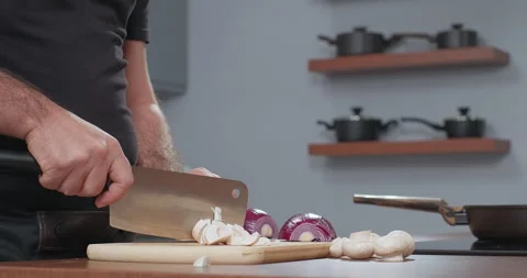 Chef cuts fresh champignon using axe. Male cooker making healthy vegetable meal Stock Footage 254548884