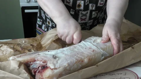 The chef cuts fresh cod fish into pieces Stock Footage 173566460