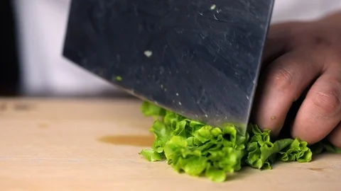 Chef cuts fresh lettuce leaf using the kitchen knife Stock Footage 118999217