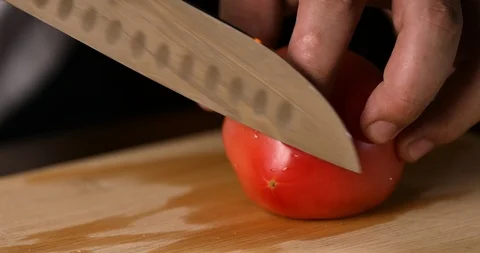 Chef cuts fresh tomato using the kitchen knife. 4K Stock Footage 118915224