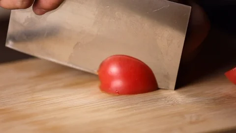 Chef cuts fresh tomato using the kitchen knife. Slow Motion Stock Footage 119001398