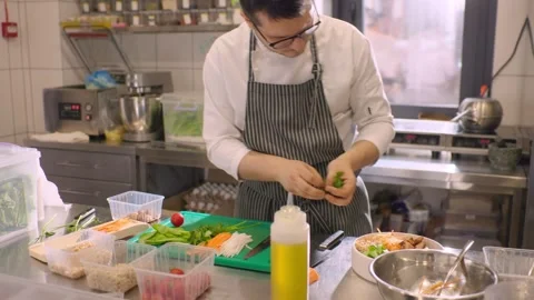 A chef cuts fresh vegetables in a spacious modern kitchen in a restaurant. Stock Footage 277133081