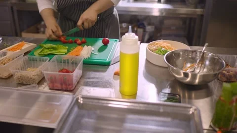 A chef cuts fresh vegetables in a spacious modern kitchen in a restaurant. Video stock 277133082