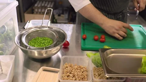 A chef cuts fresh vegetables in a spacious modern kitchen in a restaurant. Video stock 277133150